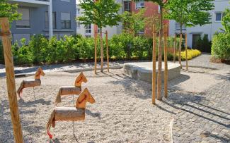 Both the trees and the three little horses find purchase in the ZinCo green roof build-up. Playground with little wooden horses and trees